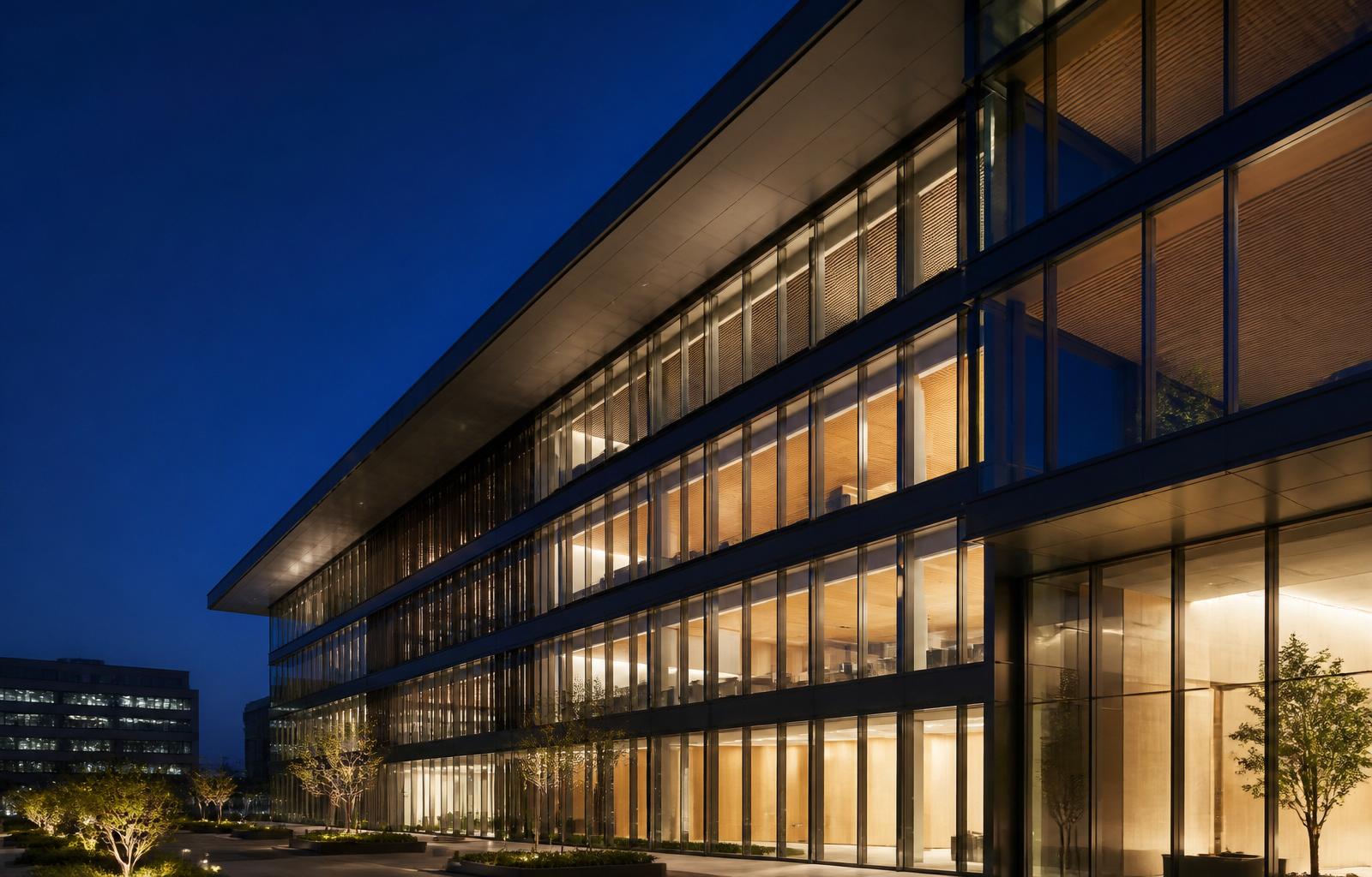 Modern architectural facade with aluminum-framed glass windows at blue hour